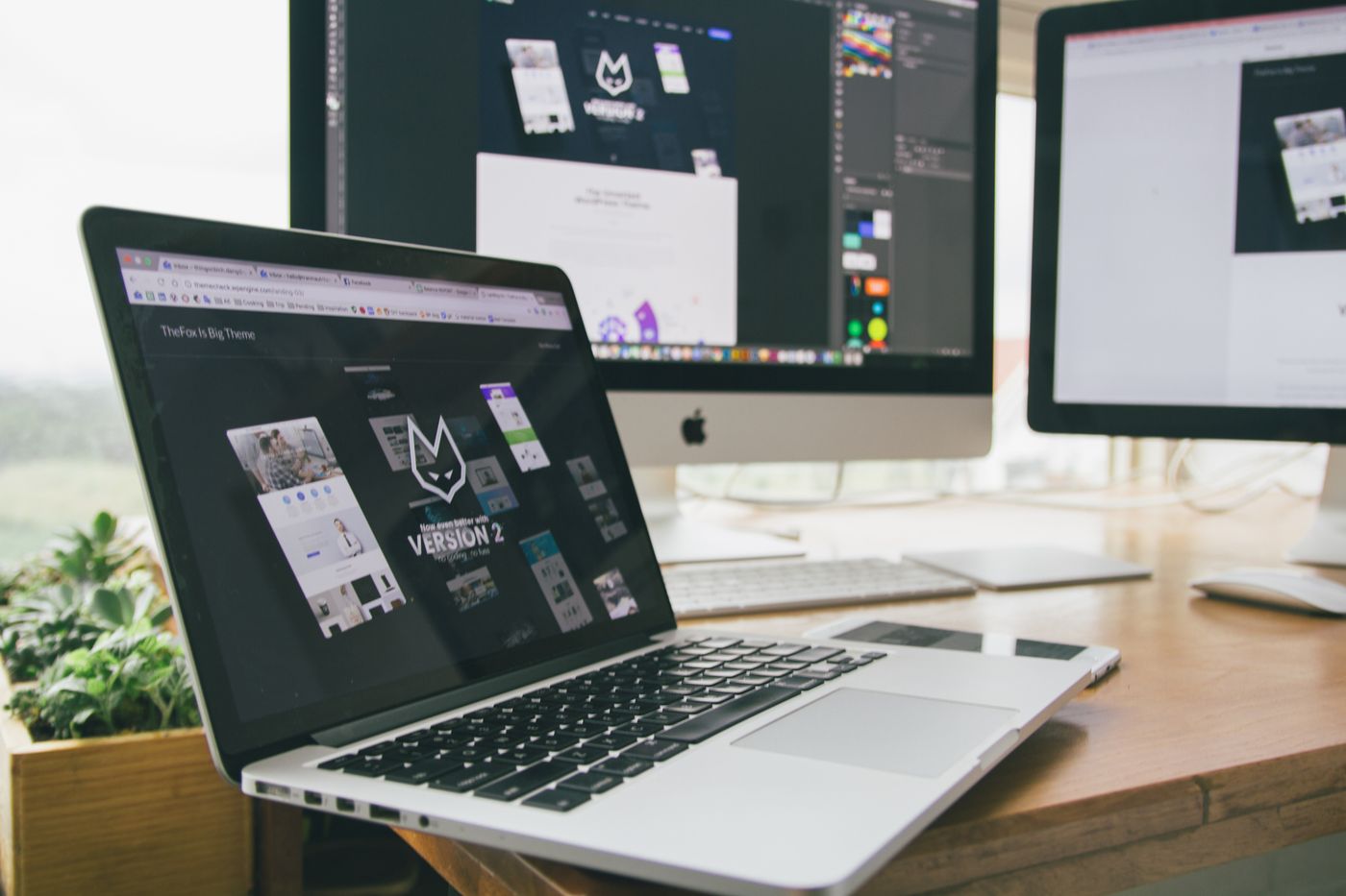 A website design open across a laptop and desktop monitor